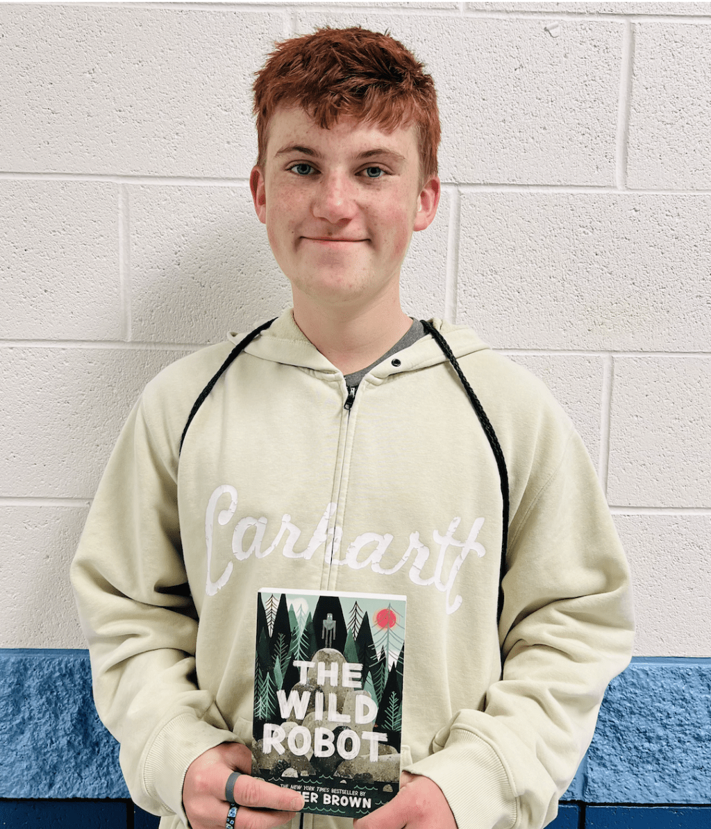 student holding a book received for earning a  praise award